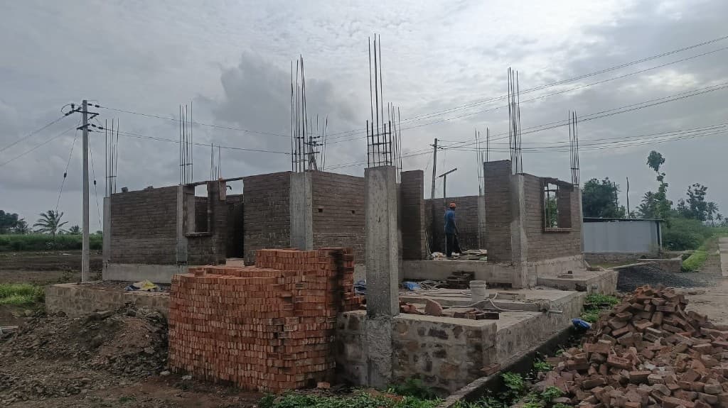 KM Construction ground-floor brickwork and RCC columns on an ongoing house site