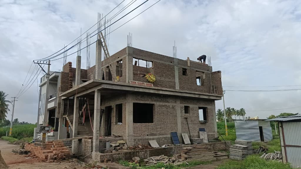 KM Construction two-storey brick residence under construction with roof-level work underway
