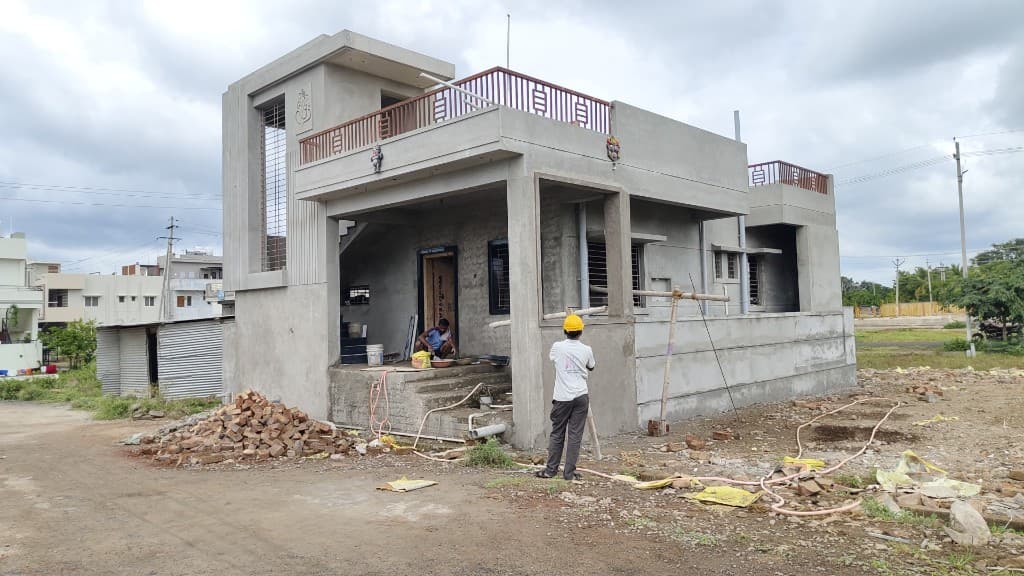 KM Construction house at exterior plaster stage with workers on site